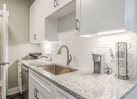 a kitchen with white cabinets and a sink