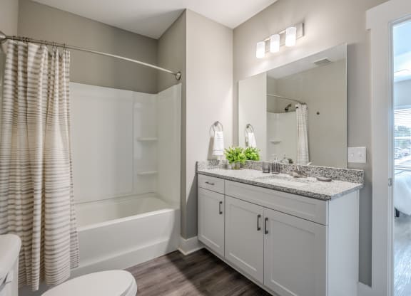 a bathroom with a large mirror and a shower and a sink