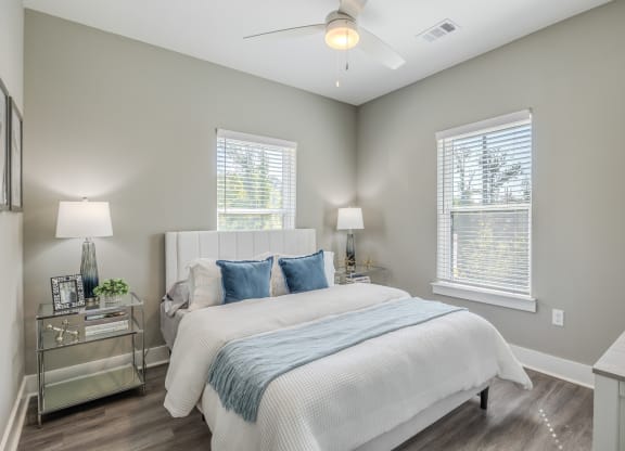 a bedroom with a bed and two windows