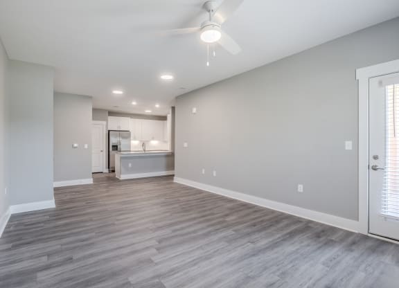 the living room and kitchen in a new home with a ceiling fan
