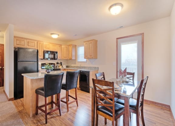 a kitchen with a breakfast bar and a table with chairs