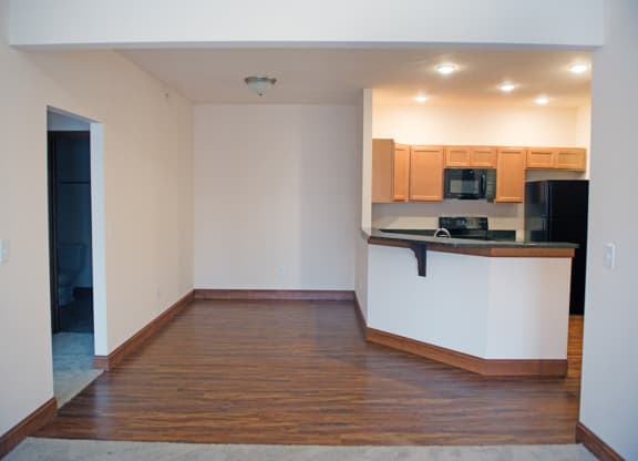 an empty living room with a kitchen and
