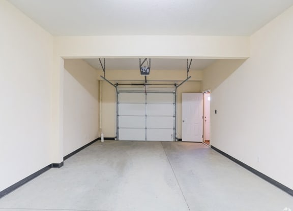 an empty garage with a white wall and a white garage door