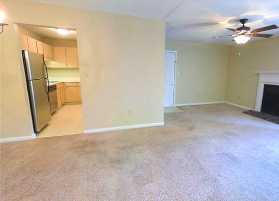 A room with a carpeted floor and a fireplace.