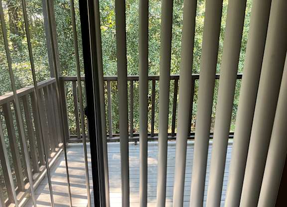 A view from a balcony looking out at a wooded area.
