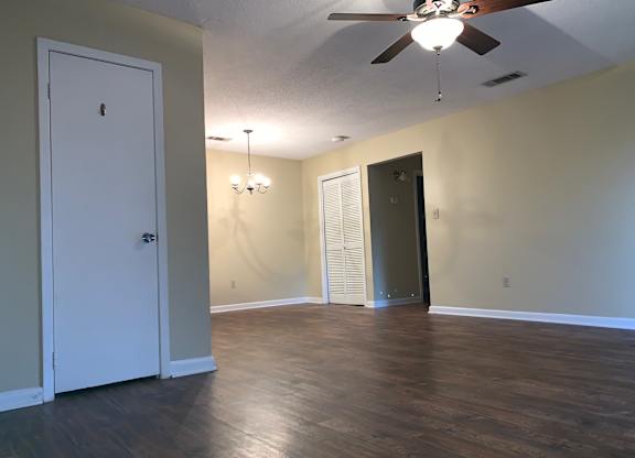 A room with a ceiling fan and a chandelier.
