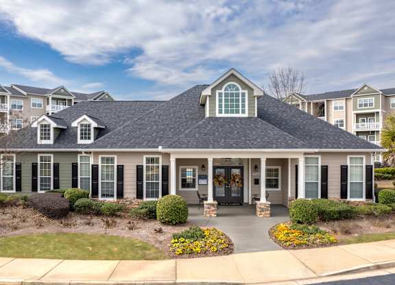 the front of a home with a large porch and a lawn