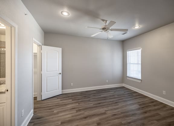 an empty room with a ceiling fan and a window
