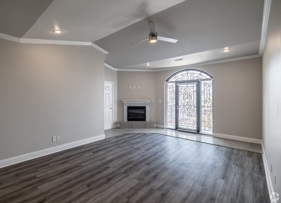 an empty living room with a fireplace and a large window