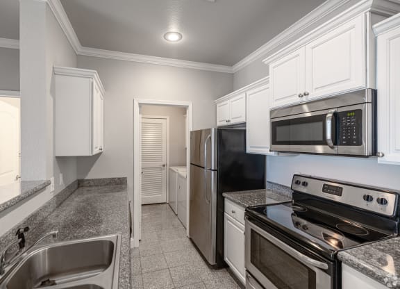 a kitchen with stainless steel appliances and white cabinets