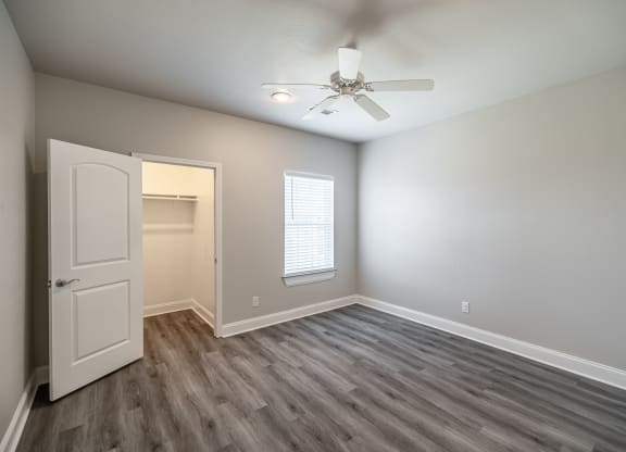 an empty room with a white door and a ceiling fan