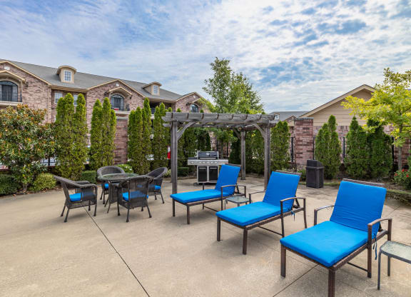 an outdoor patio with blue chairs and a gazebo