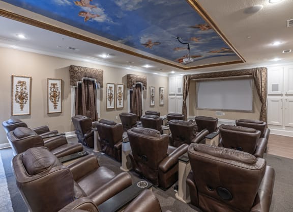 the screening room has a projector screen and leather chairs