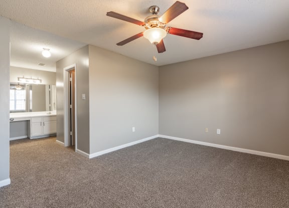 an empty living room with a ceiling fan