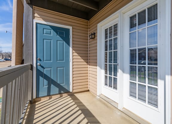 the front porch of a house with a blue door