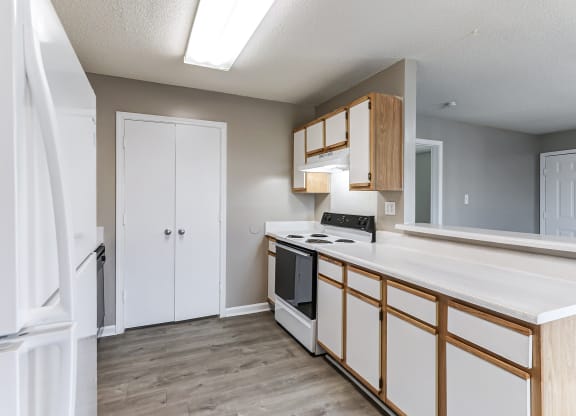 an empty kitchen with white cabinets and a white counter top