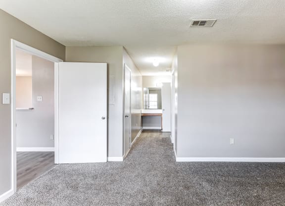 an empty room with white walls and a carpeted floor