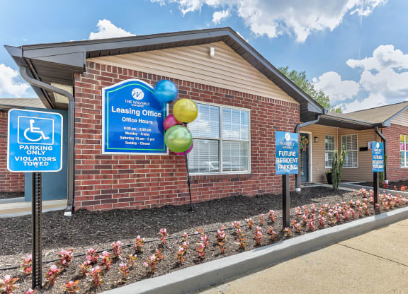a brick building with signs and balloons in front of it