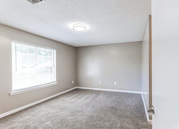 an empty room with carpet and a window