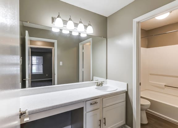 an empty bathroom with a large mirror and a sink