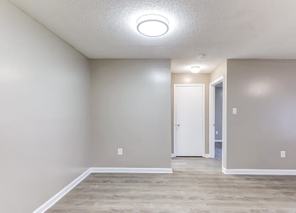an empty room with a hallway and a door to a closet