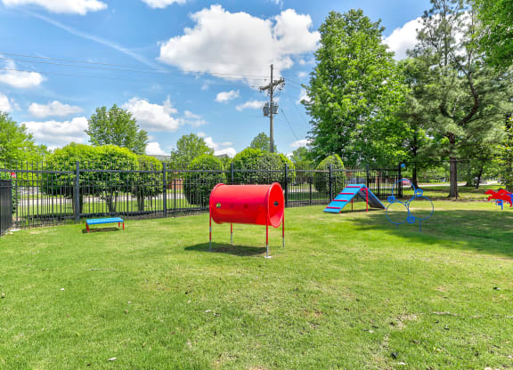 a park with a playground and a red barrel in the middle