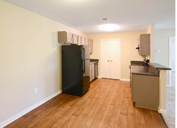 an empty kitchen with a refrigerator and a sink