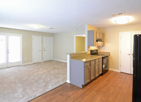 an empty kitchen and living room with a refrigerator