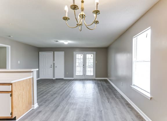 an empty living room with a chandelier
