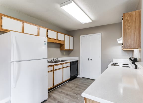 a kitchen with white appliances and wooden cabinets and a white refrigerator