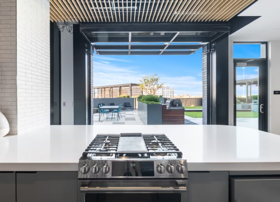 a kitchen with a stove and a view of a patio
