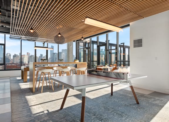 a ping pong table in a room with a view of the city