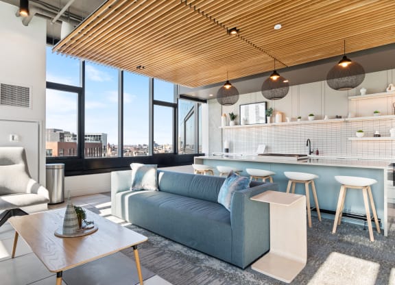 a living room with a blue couch and a kitchen with a table and chairs