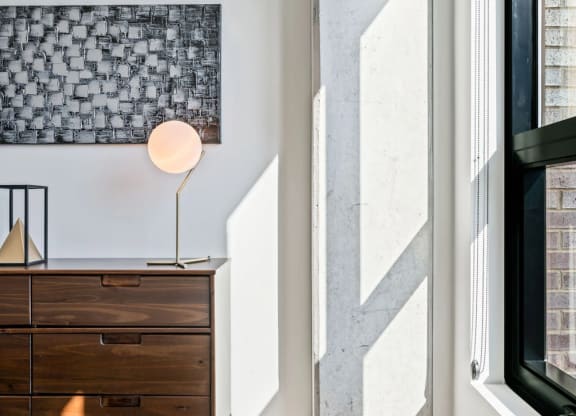a bedroom with a bed and a dresser with a lamp on top of it