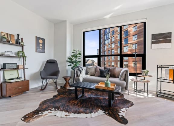a living room with a large window and hardwood floors