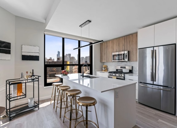 a kitchen with a large center island with a breakfast bar and stools