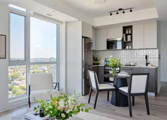 A modern kitchen with a dining table and chairs.
