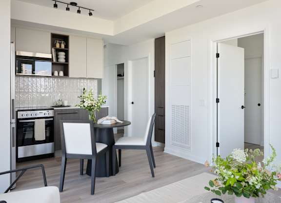 A modern kitchen with a dining table and chairs.