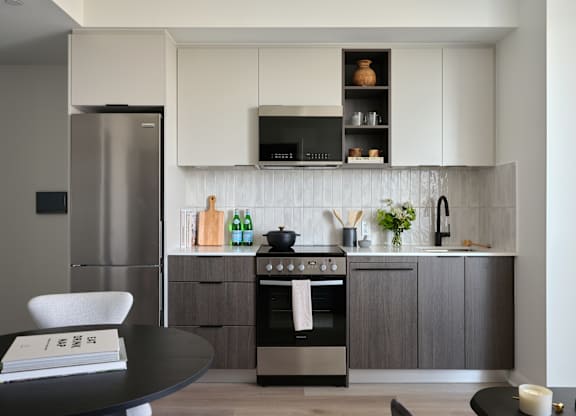 A modern kitchen with a stainless steel refrigerator and a black oven.