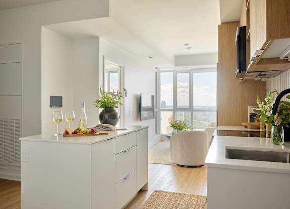 A modern kitchen with a white countertop and a large window.