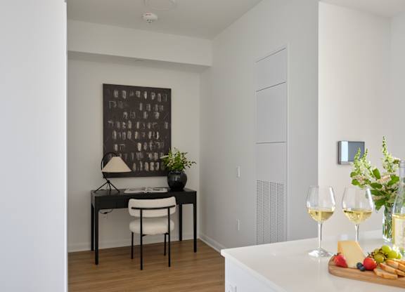 A dining table with a white chair and a black lamp with a white shade.