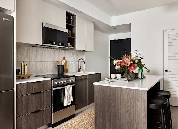 A modern kitchen with a stainless steel refrigerator and a wooden island.