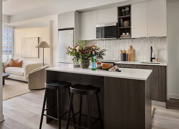 A kitchen with a white counter top and a white fridge.