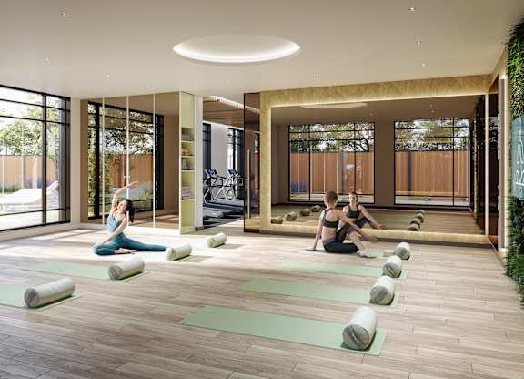 A yoga class is taking place in a spacious room with a large window.