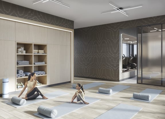 a woman sitting on the floor in a yoga room