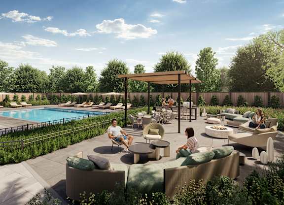 A poolside area with people sitting and enjoying the sun.