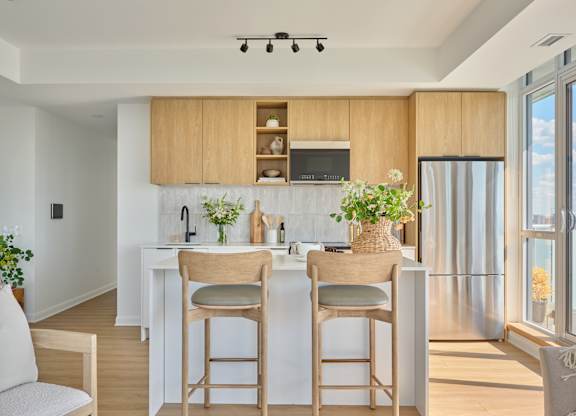 A kitchen with wooden chairs and a white counter.