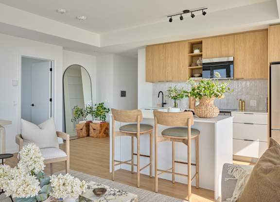 A kitchen with wooden chairs and a white counter.