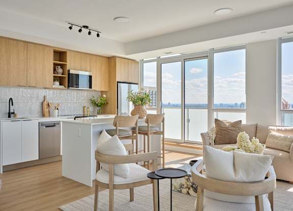 A modern kitchen with a dining area and a view of the city.