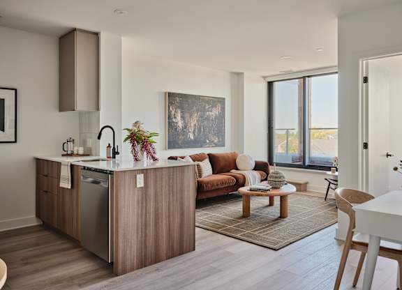 A modern kitchen with wooden cabinets and a large window.